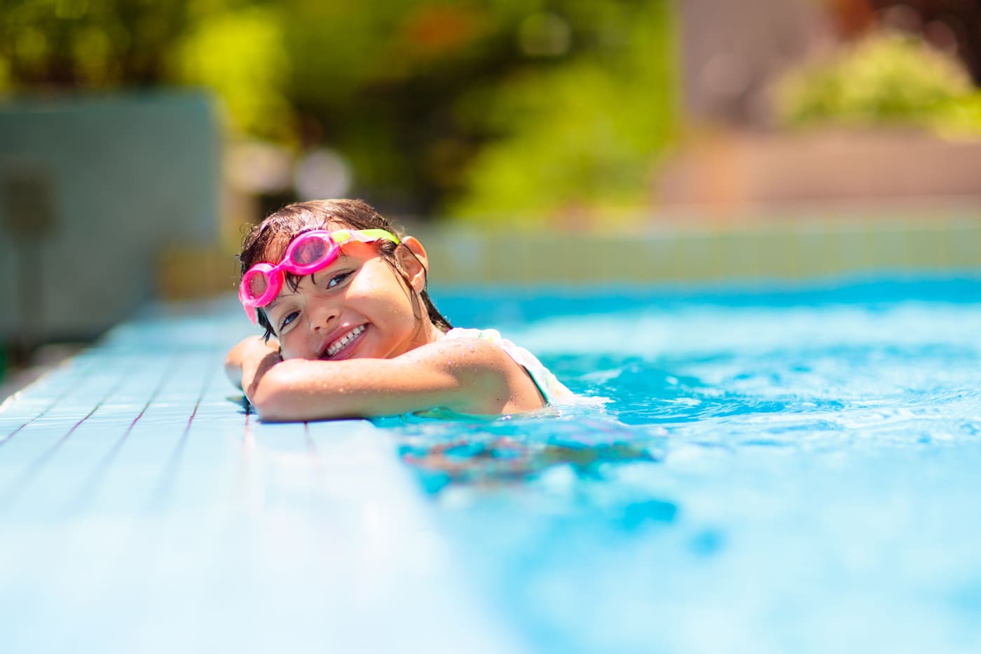 Child smiling at the edge of a clean pool