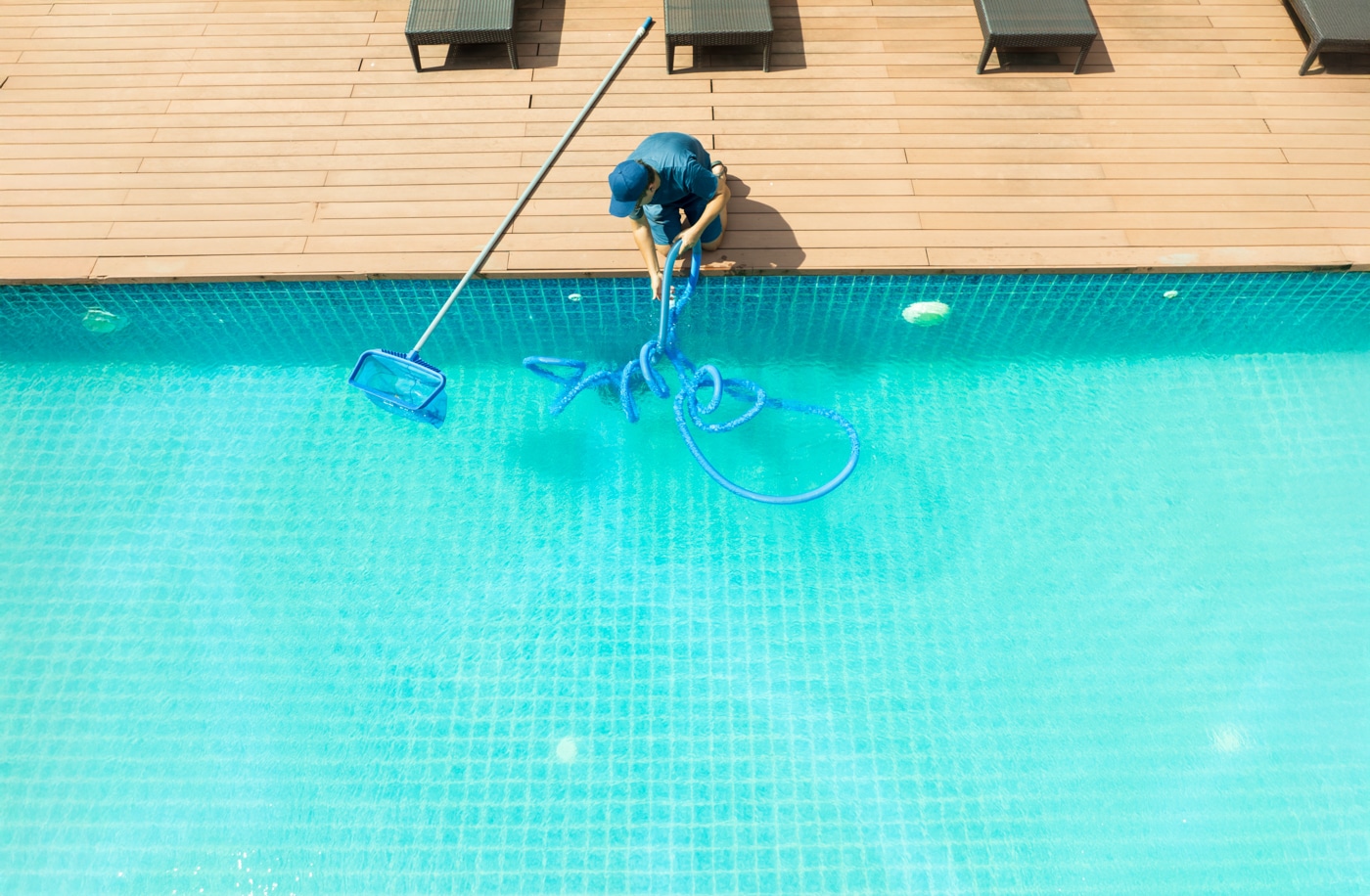 Pool technician cleaning a pool from the deck after a storm