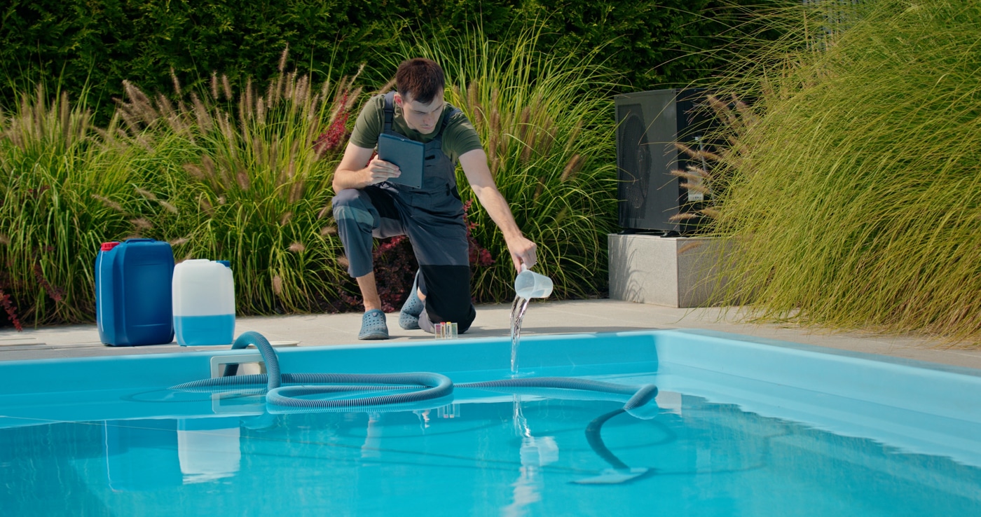 Pool technician balancing chemicals during a weekly service visit