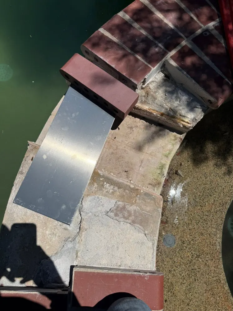 Damaged spa edge tile and coping before repair in Tucson